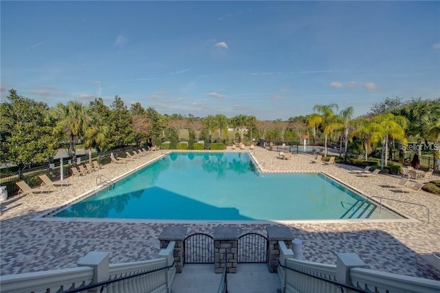 community pool featuring fence and a patio area