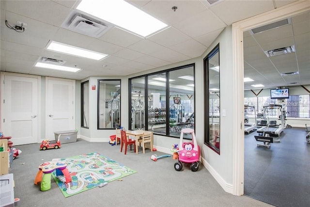 recreation room with a paneled ceiling and visible vents