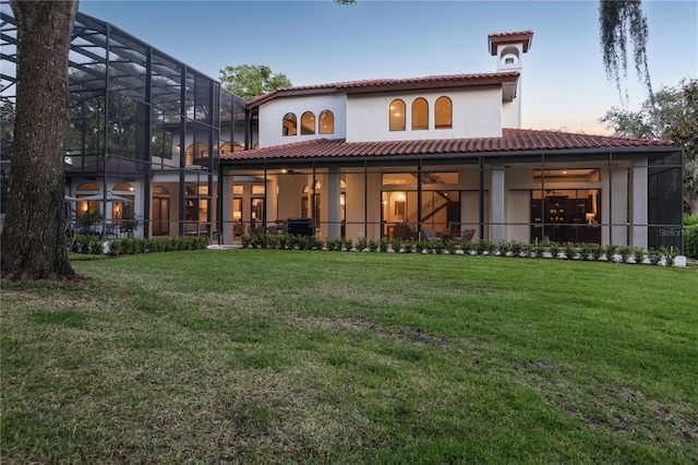1716 Greystone Ct, Longwood, FL 32779 - rear view of property featuring stucco siding, a ceiling fan, glass enclosure, a tiled roof, and a yard