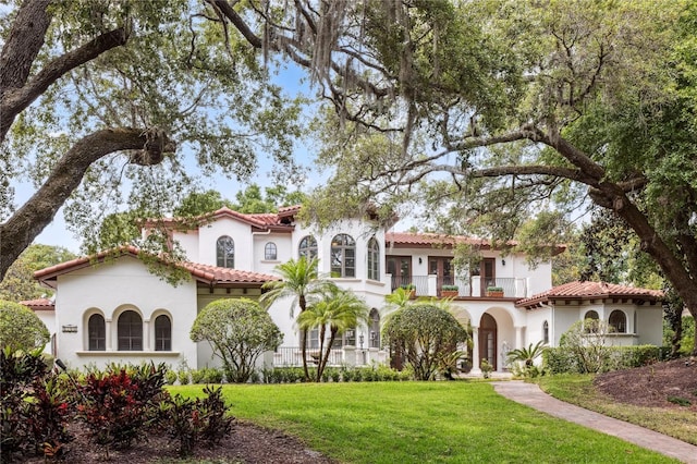 1716 Greystone Ct, Longwood, FL 32779 - mediterranean / spanish-style house with stucco siding, a tiled roof, a balcony, and a front lawn