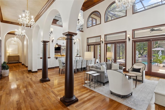 1716 Greystone Ct, Longwood, FL 32779 - living room featuring crown molding, arched walkways, an inviting chandelier, and light wood-style floors