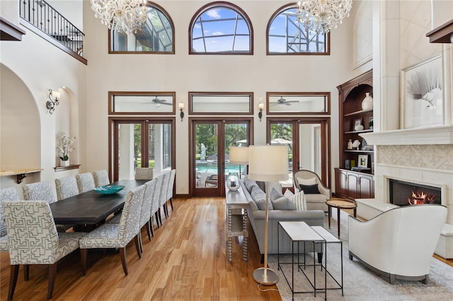 1716 Greystone Ct, Longwood, FL 32779 - living room featuring built in features, a high ceiling, a fireplace, and light wood-type flooring