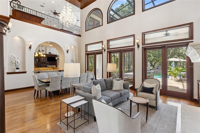 1716 Greystone Ct, Longwood, FL 32779 - living room with wood finished floors, ceiling fan with notable chandelier, and a towering ceiling