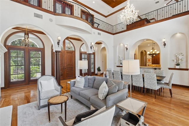 1716 Greystone Ct, Longwood, FL 32779 - living room with an inviting chandelier, arched walkways, wood finished floors, a towering ceiling, and visible vents