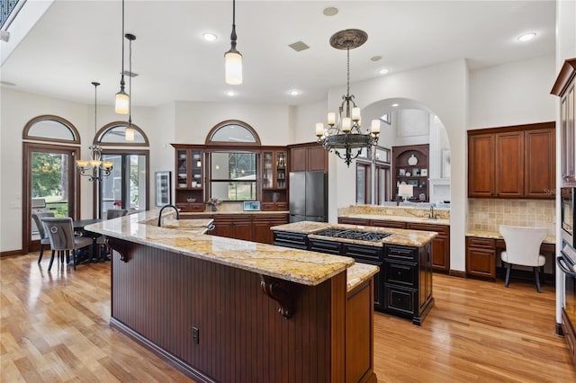 1716 Greystone Ct, Longwood, FL 32779 - kitchen featuring freestanding refrigerator, a spacious island, a notable chandelier, and light wood-type flooring