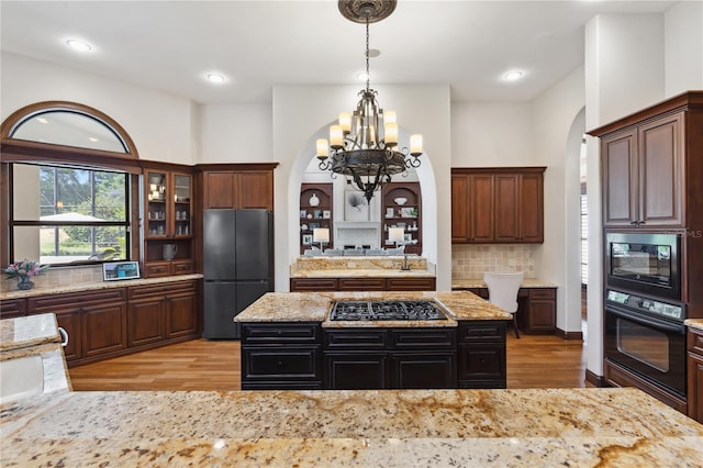 1716 Greystone Ct, Longwood, FL 32779 - kitchen featuring an inviting chandelier, arched walkways, black appliances, and light wood-type flooring