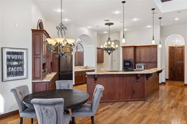 1716 Greystone Ct, Longwood, FL 32779 - kitchen with black microwave, a sink, a chandelier, freestanding refrigerator, and a toaster
