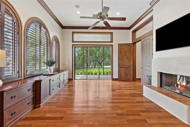 1716 Greystone Ct, Longwood, FL 32779 - interior space with crown molding, light wood-style floors, ceiling fan, a warm lit fireplace, and recessed lighting