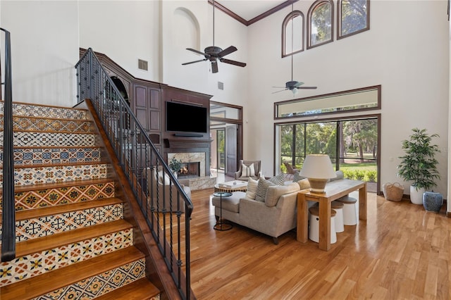 1716 Greystone Ct, Longwood, FL 32779 - living room featuring a high end fireplace, a high ceiling, light wood finished floors, and stairs