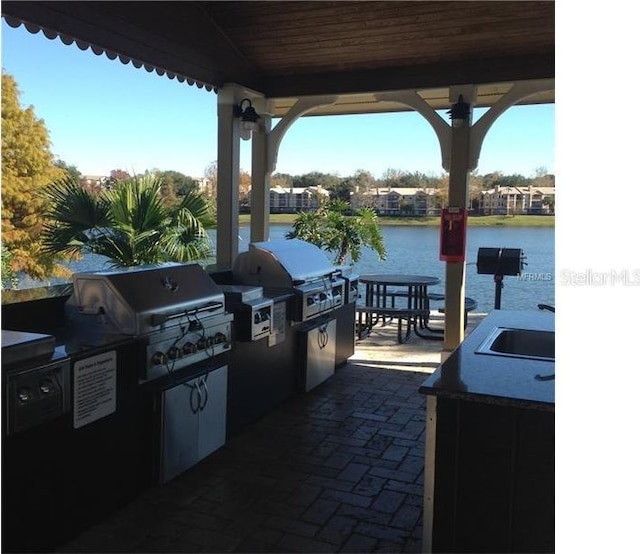1071 S Hiawassee Rd Unit 1211, Orlando, FL 32835 - view of patio / terrace featuring a water view, grilling area, a sink, and area for grilling