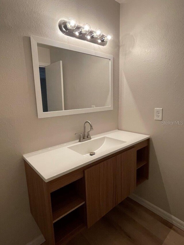 1071 S Hiawassee Rd Unit 1211, Orlando, FL 32835 - bathroom with baseboards, a textured wall, wood finished floors, and vanity