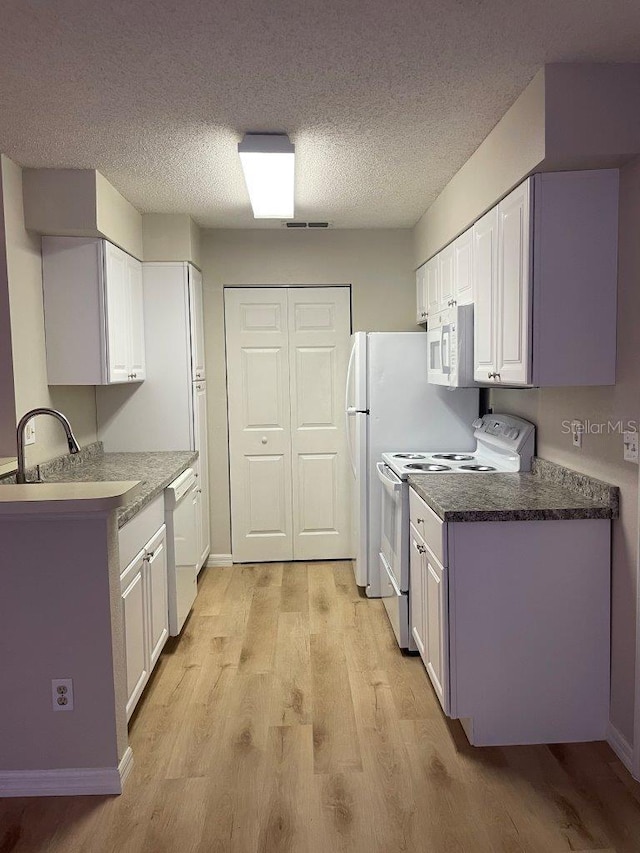 1071 S Hiawassee Rd Unit 1211, Orlando, FL 32835 - kitchen with white appliances, light wood-type flooring, a textured ceiling, white cabinetry, and a sink