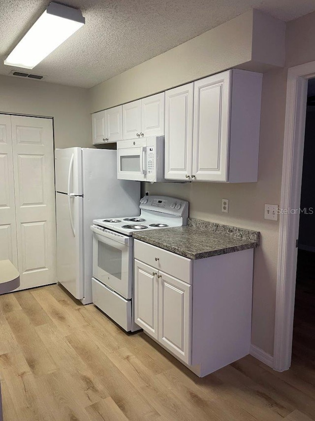 1071 S Hiawassee Rd Unit 1211, Orlando, FL 32835 - kitchen featuring white appliances, white cabinets, visible vents, and light wood finished floors