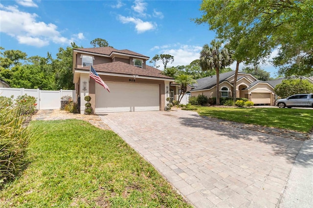 mediterranean / spanish-style house featuring fence, a front lawn, a garage, stucco siding, and decorative driveway