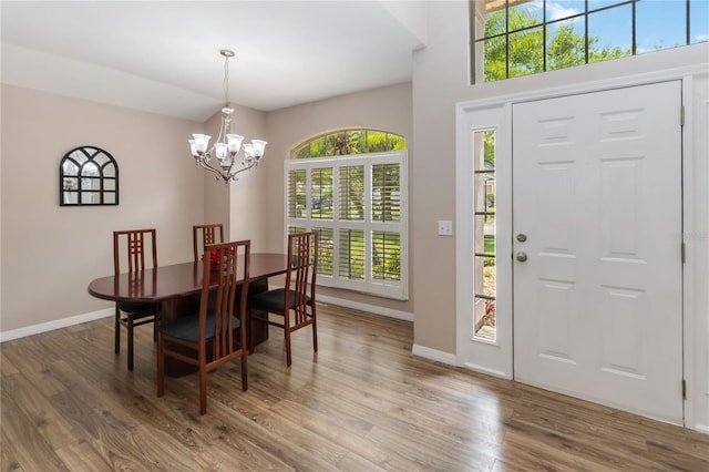 interior space featuring baseboards, a notable chandelier, and wood finished floors