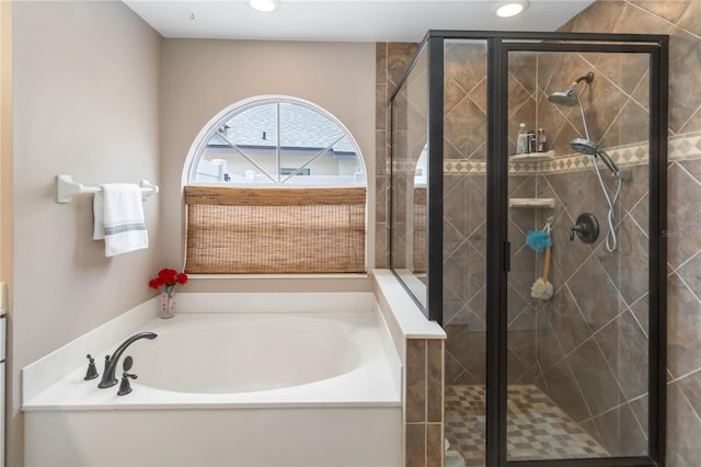 bathroom with a shower stall, a garden tub, and recessed lighting