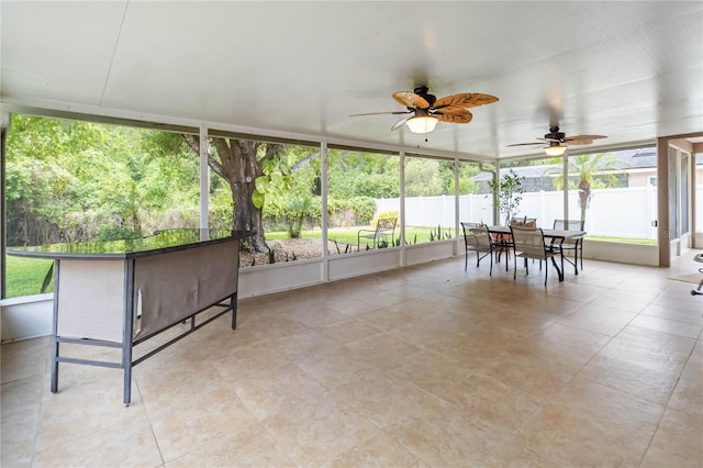 sunroom featuring a ceiling fan and outdoor dining space