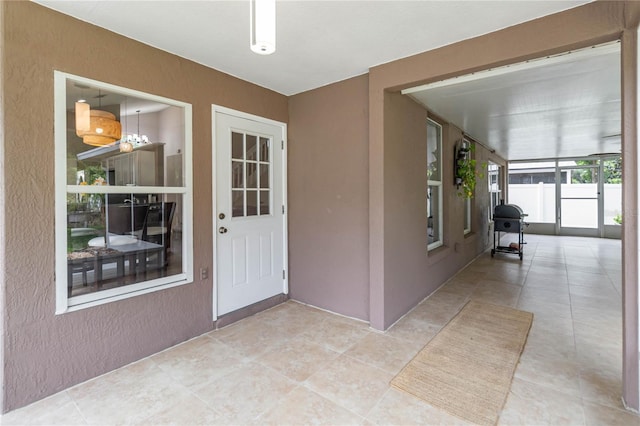 property entrance featuring fence, stucco siding, and a patio area