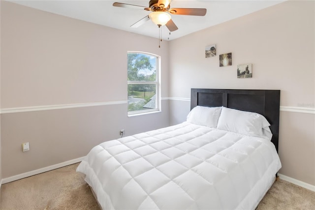 bedroom with baseboards, a ceiling fan, and light carpet