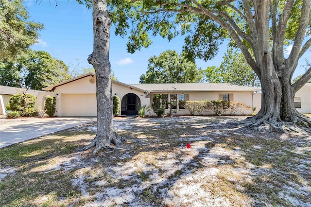 ranch-style home with an attached garage, driveway, and stucco siding