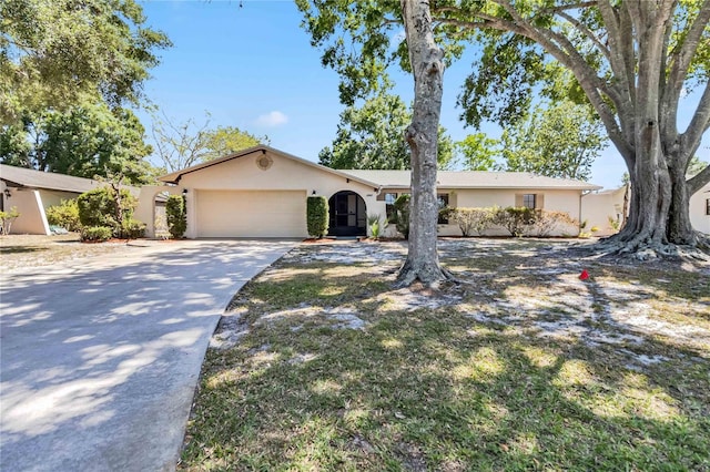 single story home featuring a garage, stucco siding, and driveway