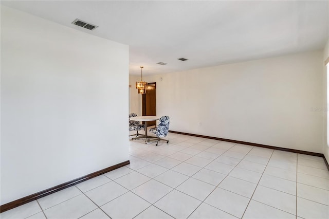 empty room featuring an inviting chandelier, baseboards, and visible vents
