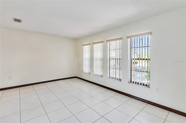spare room with baseboards and visible vents