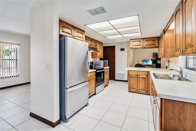 kitchen featuring visible vents, appliances with stainless steel finishes, a sink, under cabinet range hood, and light tile patterned flooring