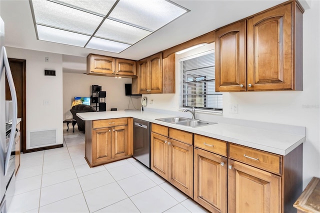 kitchen with a peninsula, brown cabinetry, a sink, and dishwasher