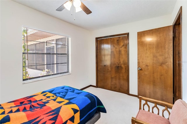 carpeted bedroom featuring baseboards and a ceiling fan