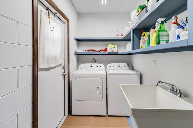 laundry area featuring laundry area, a sink, light tile patterned floors, and washing machine and dryer