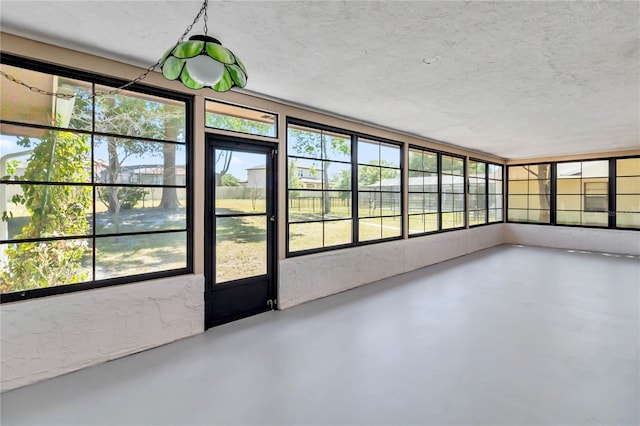 unfurnished sunroom featuring concrete floors and a textured ceiling
