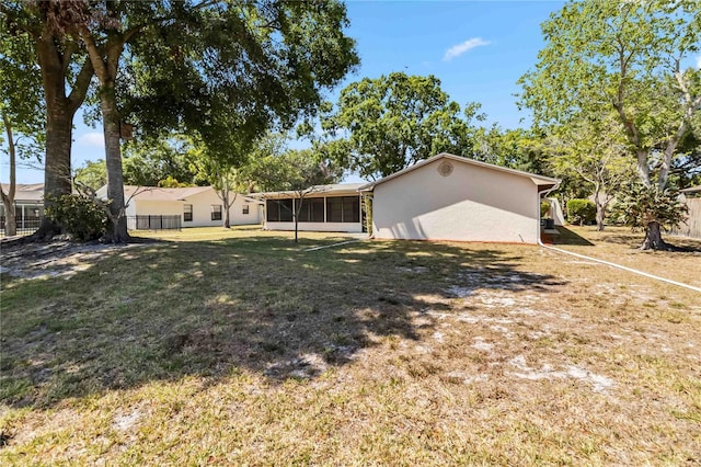 view of yard with fence and a sunroom