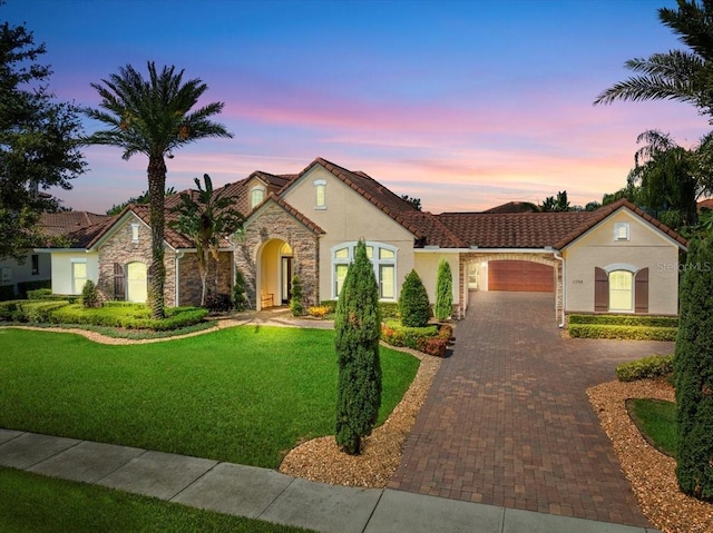 11502 Waterstone Loop Dr, Windermere, FL 34786 - view of front of home with decorative driveway, a garage, stucco siding, a yard, and stone siding