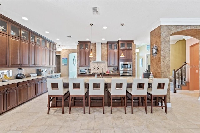 11502 Waterstone Loop Dr, Windermere, FL 34786 - kitchen with wall chimney range hood, stainless steel appliances, arched walkways, backsplash, and recessed lighting