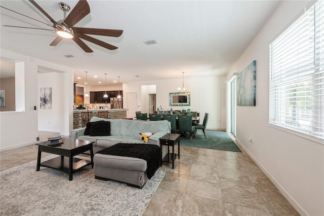 2952 Boating Blvd, Kissimmee, FL 34746 - living room with stone finish flooring, baseboards, visible vents, and ceiling fan with notable chandelier