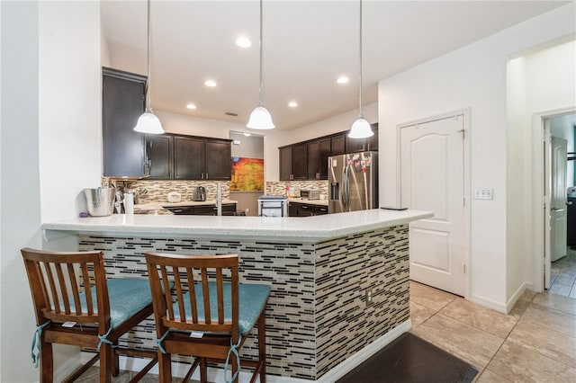 2952 Boating Blvd, Kissimmee, FL 34746 - kitchen with dark brown cabinetry, stainless steel fridge, light countertops, recessed lighting, and backsplash