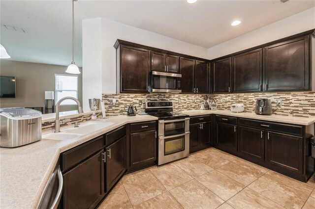 2952 Boating Blvd, Kissimmee, FL 34746 - kitchen featuring tasteful backsplash, dark brown cabinets, a sink, light countertops, and stainless steel appliances