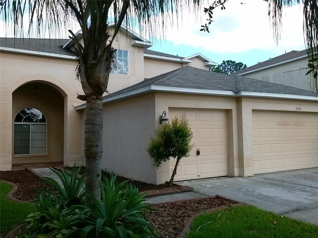2011 N 61st St, Tampa, FL 33619 - view of side of home with stucco siding, a garage, and driveway