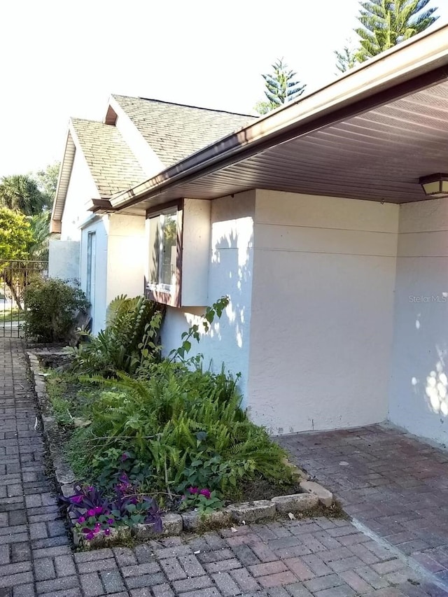 2011 N 61st St, Tampa, FL 33619 - view of property exterior featuring stucco siding and a shingled roof