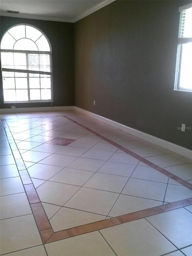 2011 N 61st St, Tampa, FL 33619 - spare room featuring tile patterned flooring, ornamental molding, baseboards, and inlaid floor details