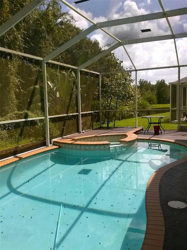 2011 N 61st St, Tampa, FL 33619 - view of pool featuring a pool with connected hot tub, glass enclosure, and a patio area