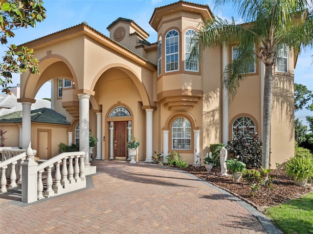 view of front facade with a tile roof and stucco siding
