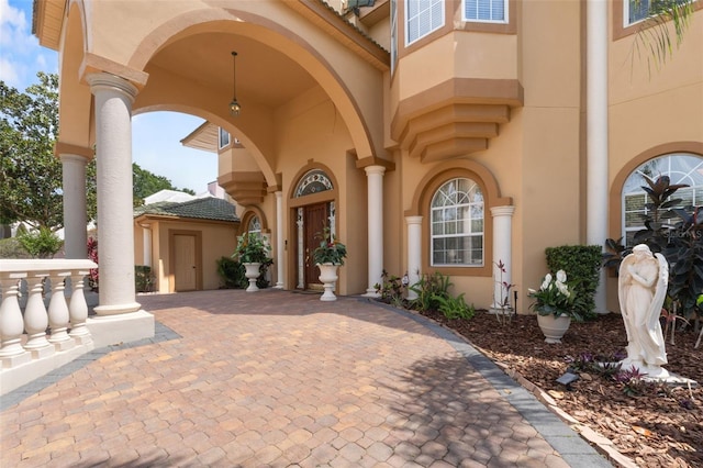 doorway to property with stucco siding and a tiled roof