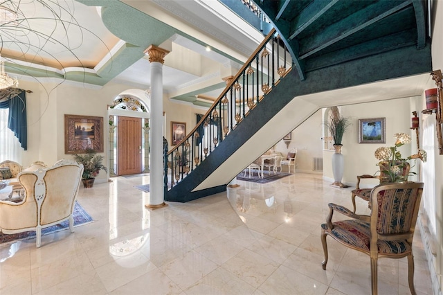 entryway featuring ornate columns, stairs, a high ceiling, and a wealth of natural light