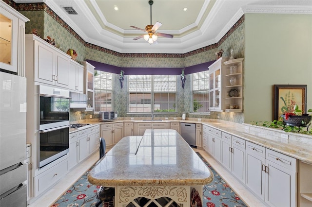 kitchen featuring a ceiling fan, appliances with stainless steel finishes, open shelves, a sink, and ornamental molding