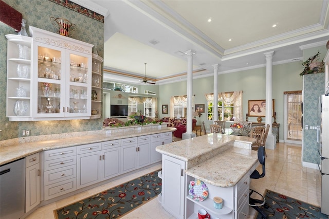 kitchen featuring ornamental molding, open shelves, a tray ceiling, and ornate columns