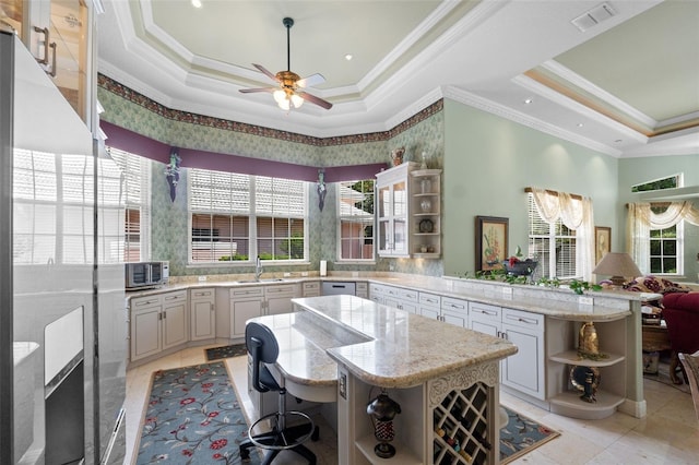 kitchen with a ceiling fan, visible vents, open shelves, a peninsula, and a tray ceiling