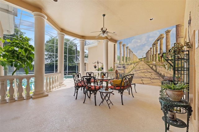 view of patio / terrace with glass enclosure, ceiling fan, and an outdoor pool