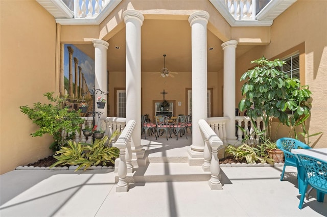 property entrance with a porch, ceiling fan, outdoor dining space, and stucco siding